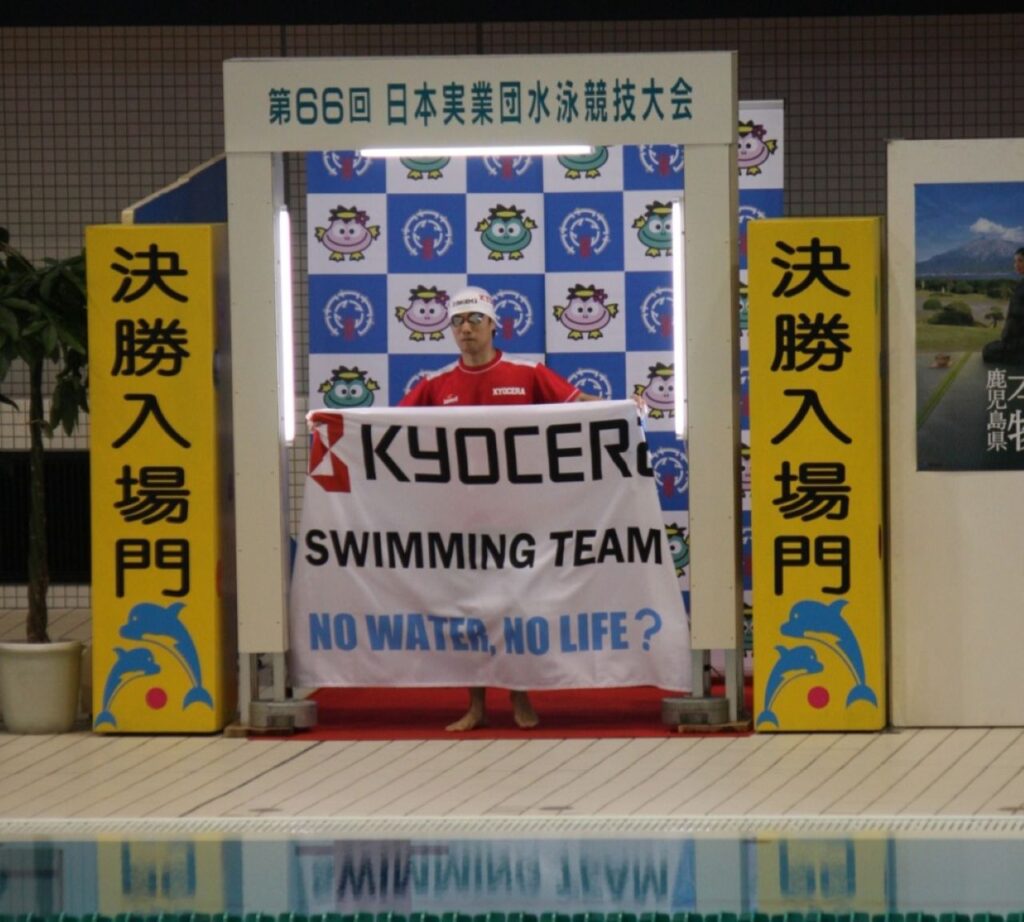横断幕を掲げる水泳選手