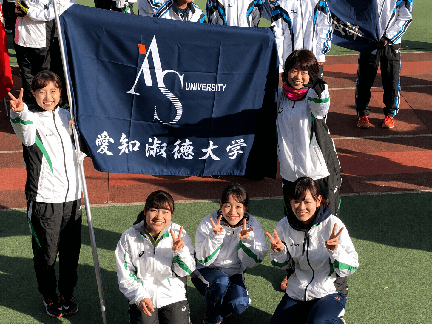 大学の運動会で校旗を掲げる学生たち