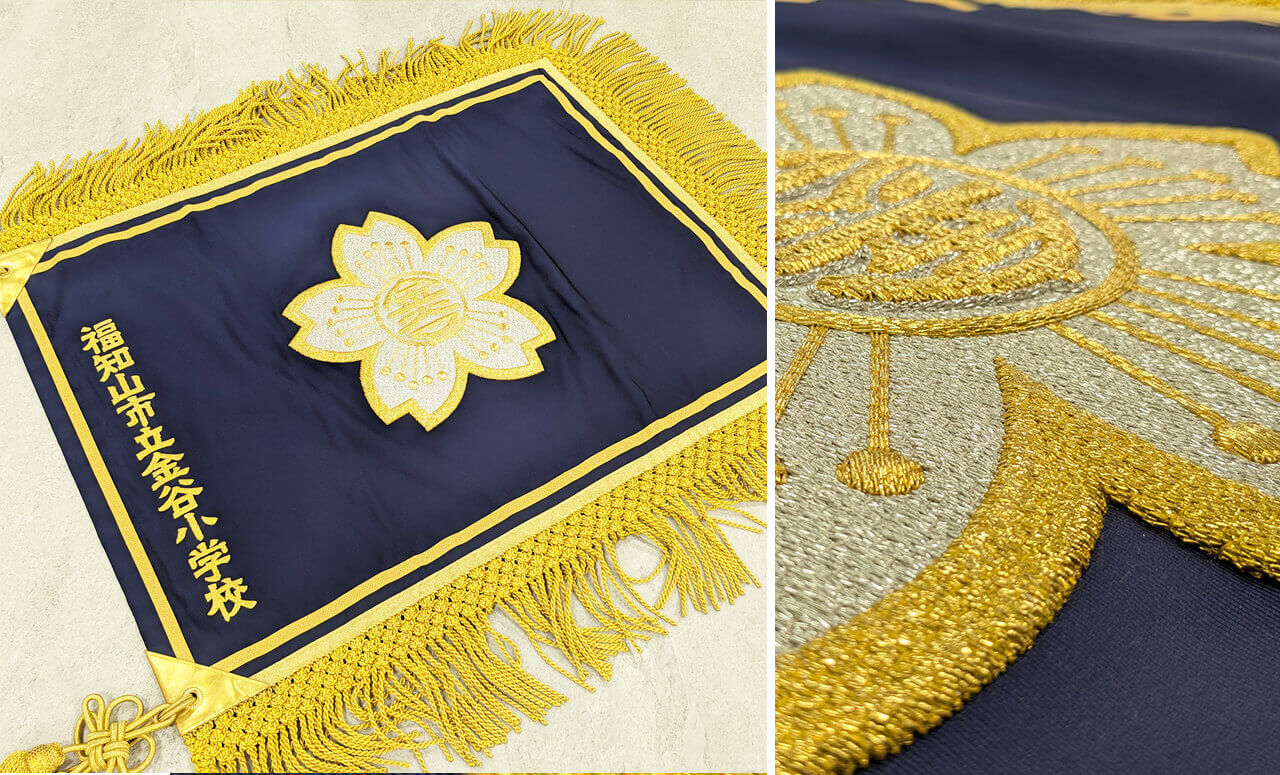 金糸・銀糸の刺繍で校章を仕上げた房付きの校旗（福知山市立金谷小学校）