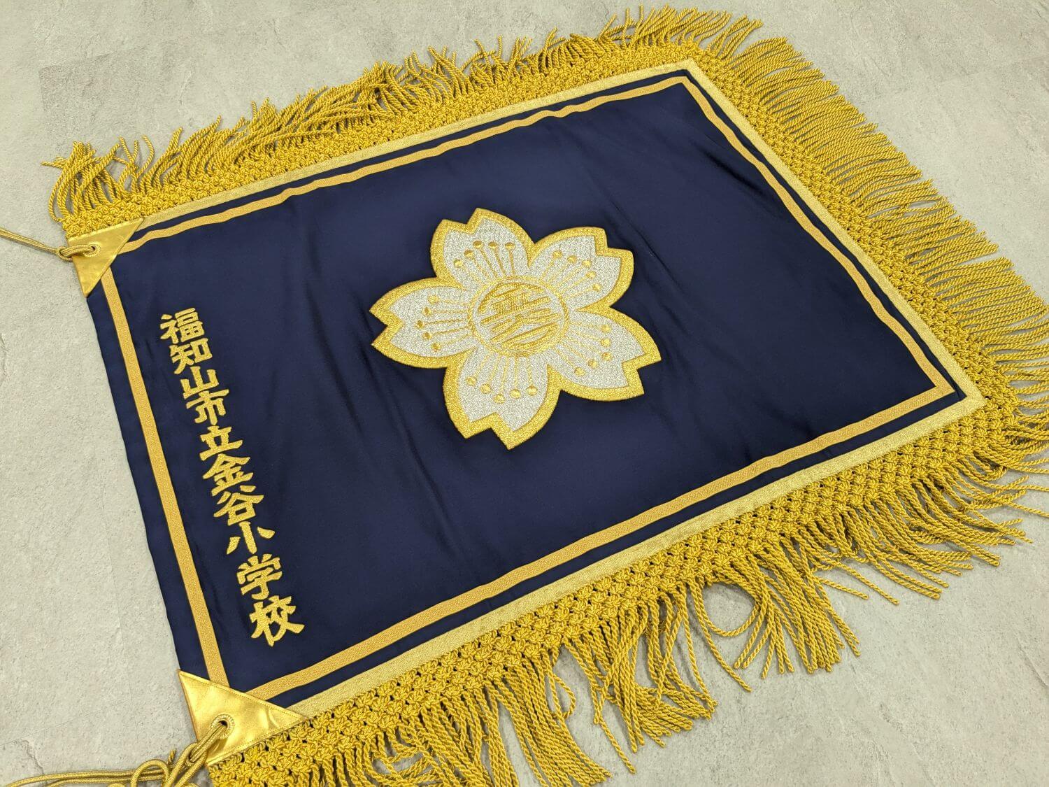 金糸の刺繍とフレンジをあしらった校旗の現物サンプル